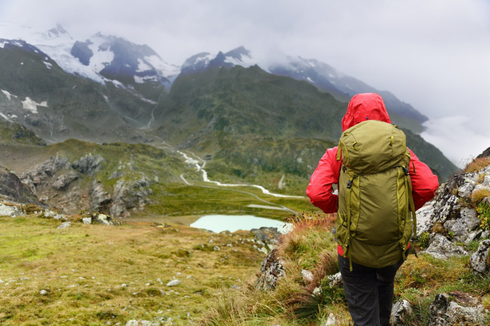 Hiking hiker on trek in mountains with backpack