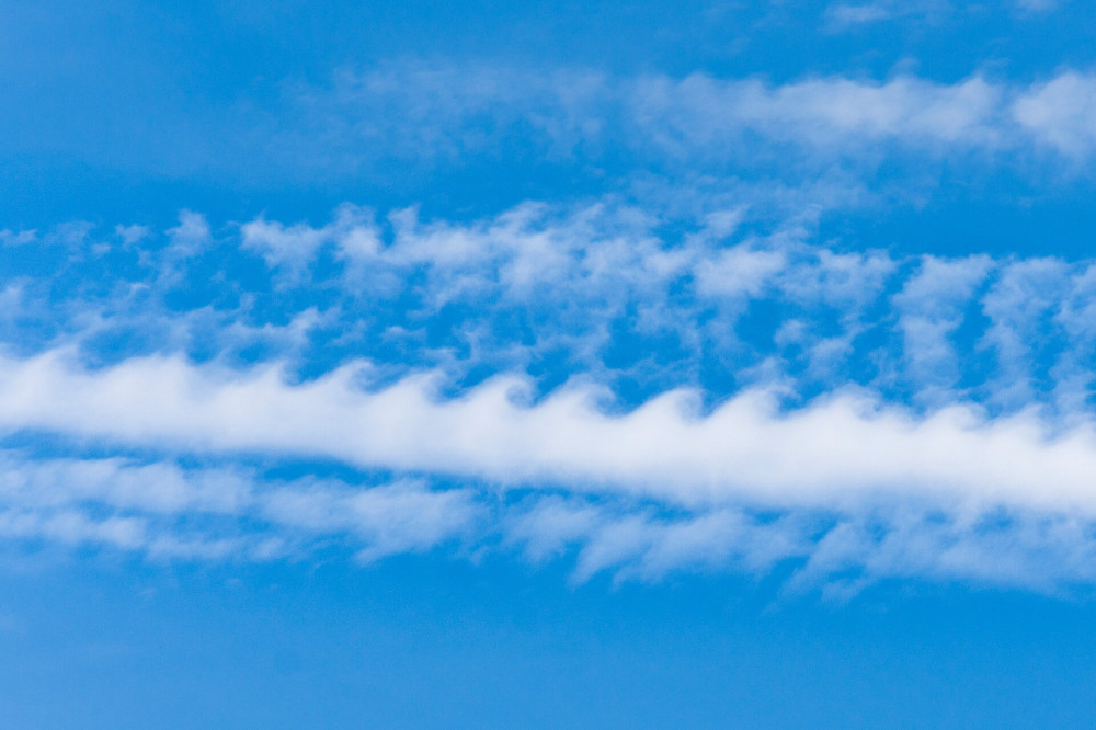 Kelvin Helmholtz instability clouds wavy on blue sky.